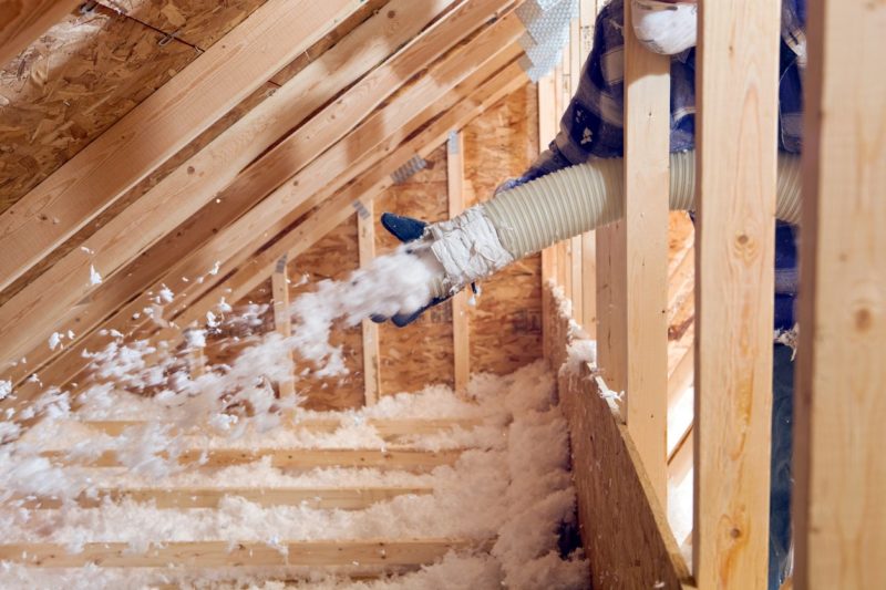 applying blown in insulation in an attic